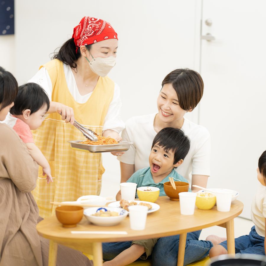 こどもカフェのイメージ：みんなで食卓を囲むこどもたちとスタッフ