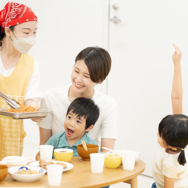 おやつを配るスタッフとよろこぶこども（イメージ）